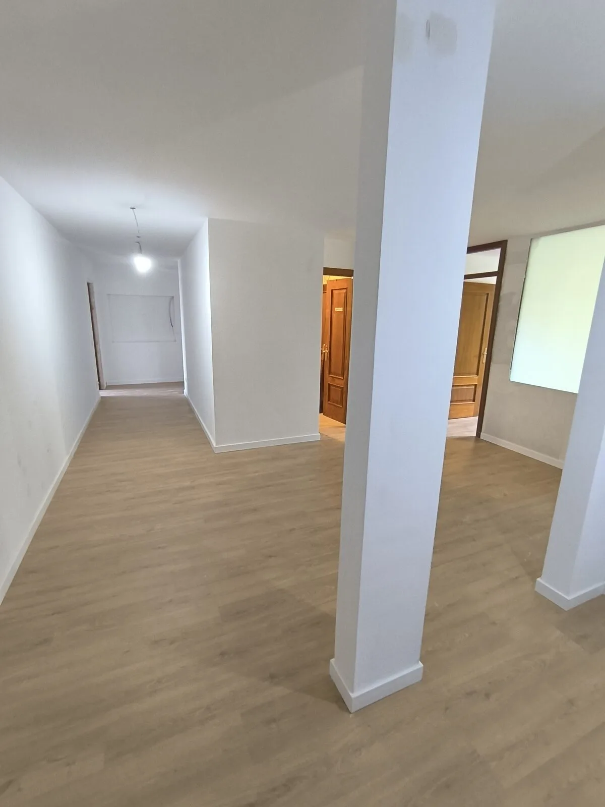 El mismo tipo de salón ya terminado, con suelo continuo y paso abierto al resto de la vivienda